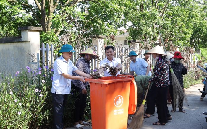 Bí thư Đảng ủy xã Xuân Mai Hoàng Xuân Hiến (người ngoài cùng phía bìa trái) tham gia vệ sinh môi trường cùng nhân dân thôn Trí Thủy. Ảnh: Kim Nhuệ