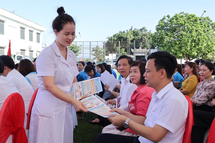 Nhân viên y tế xã Xuân Mai phát tờ rơi hướng dẫn người dân biện pháp diệt muỗi, phòng bệnh sốt xuất huyết. Ảnh: Kim Nhuệ
