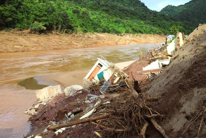 Nhiều nhà cửa của người dân ở xã Mỹ Lý bị lũ cuốn trôi, đổ sập xuống sông Nậm Nơn. Ảnh: Xuân Tiến - TTXVN
