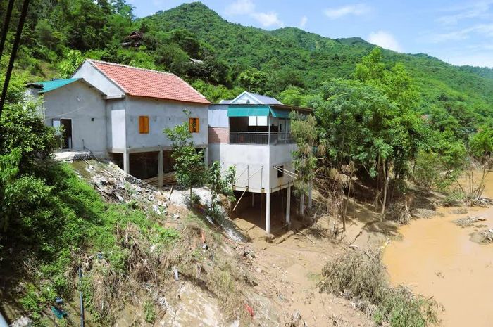 Những ngôi nhà bên bờ vực sạt lở trên sông Lam đối diện với nguy cơ tái diễn tình trạng sạt lở, uy hiếp tài sản, tính mạng người dân nếu trời tiếp tục mưa. Ảnh: Xuân Tiến - TTXVN