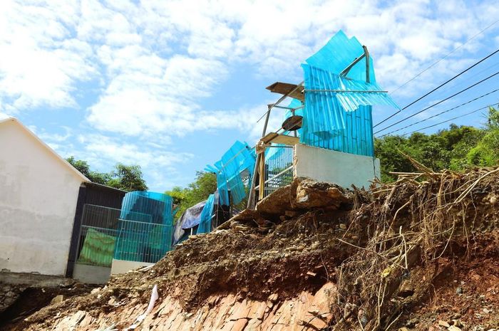 Nhà dân sinh sống dọc quốc lộ 7 thuộc địa bàn xã Tương Dương (tỉnh Nghệ An) bị lũ cuốn trôi hoàn toàn chỉ còn lại bức tường rào và cổng ngõ nằm chênh vênh bên bờ vực. Ảnh: Xuân Tiến - TTXVN
