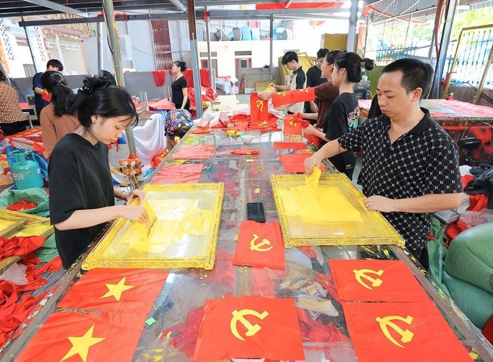Từng công đoạn, từng lá cờ được người dân nơi đây thực hiện một cách tỉ mỉ. Ảnh: Lê Đông - TTXVN