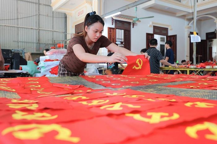 Từng công đoạn, từng lá cờ được người dân nơi đây thực hiện một cách tỉ mỉ. Ảnh: Lê Đông - TTXVN