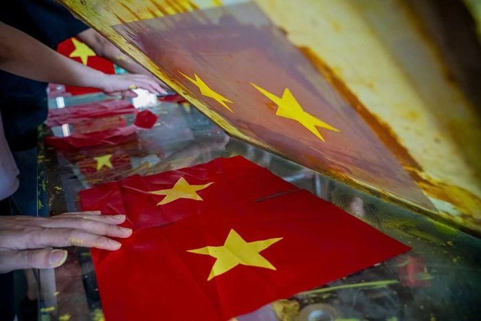 Từng công đoạn, từng lá cờ được người dân nơi đây hoàn thành một cách tỉ mỉ. Ảnh: Khánh Hòa - TTXVN