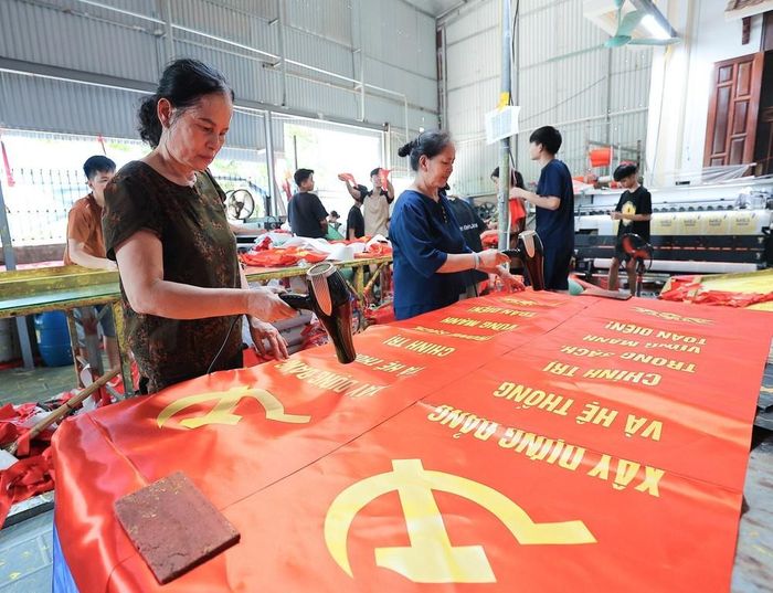 Từng công đoạn, từng lá cờ được người dân nơi đây thực hiện một cách tỉ mỉ. Ảnh: Lê Đông - TTXVN