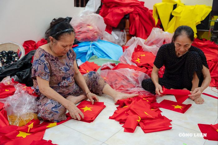 Các nhân công đang gấp gọn những lá cờ, chờ phân phối ra thị trường trong nước.