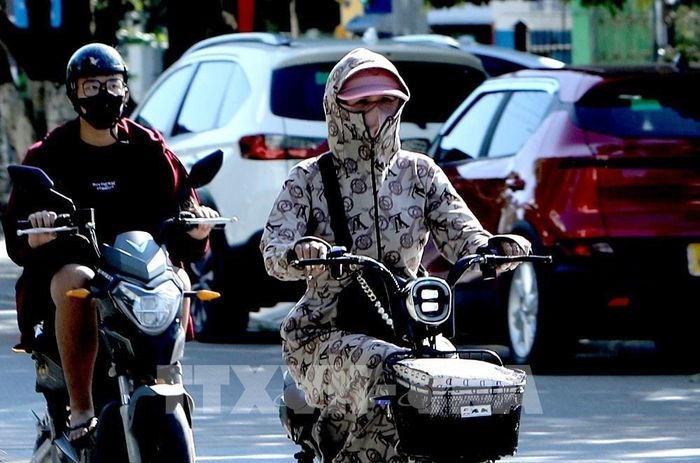 Trong ngày nắng nóng, trang phục “kín mít” là một lựa chọn tối ưu để đối phó với thời tiết nắng nóng. Ảnh chụp tại đường Tôn Đức Thắng phường Vĩnh Phúc Ảnh: Hoàng Hùng -TTXVN