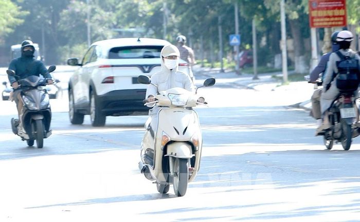 Trong ngày nắng nóng, trang phục “kín mít” là một lựa chọn tối ưu để đối phó với thời tiết nắng nóng. Ảnh chụp tại đường Tôn Đức Thắng phường Vĩnh Phúc Ảnh: Hoàng Hùng -TTXVN
