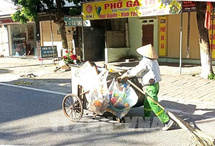 Người lao công quét đường từ sớm nhưng vẫn không tránh được ánh mặt trời gay gắt ngày hè nắng gắt. Ảnh chụp tại đường Chùa Hà phường Vĩnh Phúc tỉnh Phú Thọ. Ảnh: Hoàng Hùng -TTXVN 