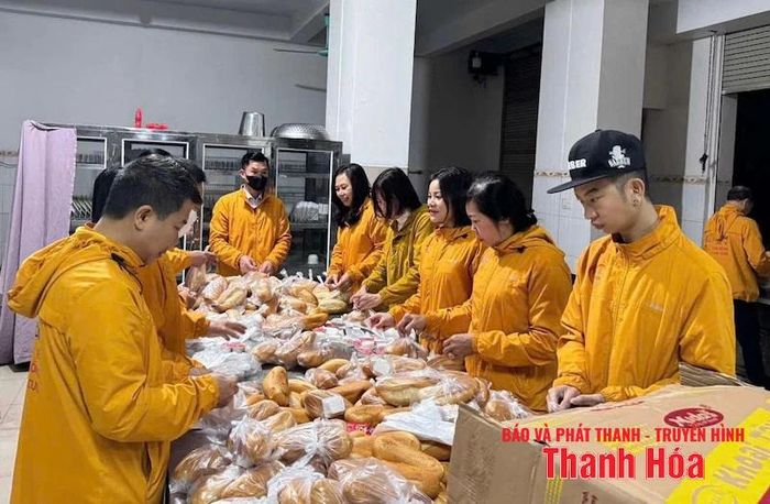 Các thành viên của nhóm“Chia sẻ cuộc sống và nụ cười” chuẩn bị bánh mỳ để trao cho các bệnh nhân nghèo.