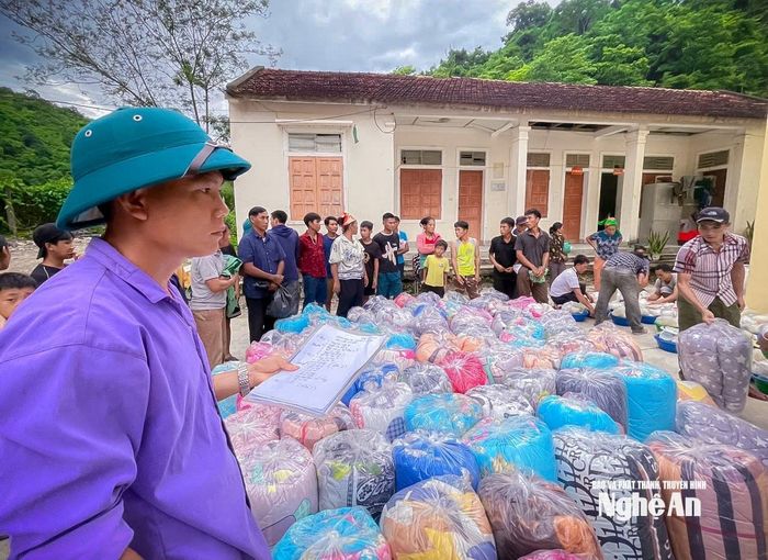 Cán bộ xã Mường Típ phân phối quà cho các hộ dân bị thiên tai. Ảnh: PTHT
