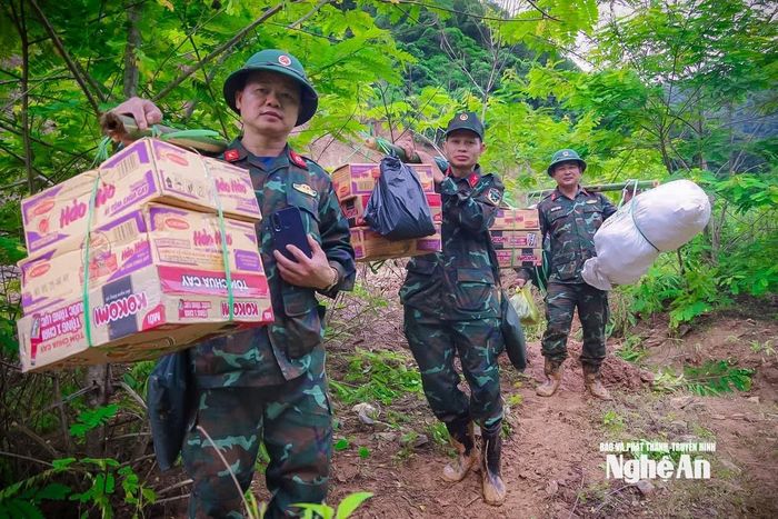 Các cán bộ, chiến sĩ Đoàn Kinh tế Quốc phòng 4 gánh hàng, đi bộ 7 km vào cứu trợ cho người dân xã Mường Típ. Ảnh: PTHT