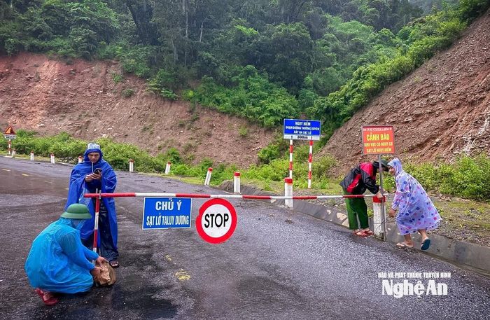 Cán bộ xã Mường Típ lập rào chắn ngăn chặn người dân qua lại khu vực nguy hiểm trong mưa lũ. Ảnh: PTHT