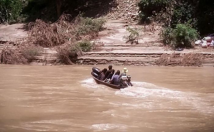Ca nô chở người dân nước bạn cùng quà cứu trợ trở về bản Na Mương. Ảnh: Vi Văn Sơn