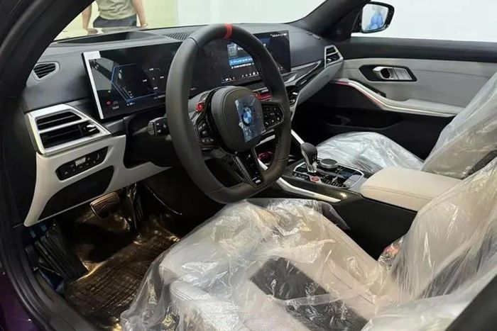 Tiến vào bên trong BMW M3 2024, người dùng sẽ bắt gặp vô lăng 3 chấu với thiết kế vát đáy thể thao mới. Vô lăng M này được bọc da với chấu cải tiến và vạch chỉ hướng 12 giờ màu đỏ. Trên vô lăng còn có 2 nút bấm M để chọn chế độ lái và chỉnh màn hình cong phía sau.