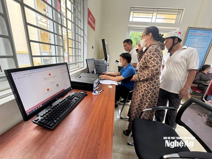 Hướng dẫn, hỗ trợ công nhận nhập dữ liệu thủ tục hành chính vào Cổng dịch vụ công trực tuyến tại phường Trường Vinh. Ảnh: Nguyễn Hải
