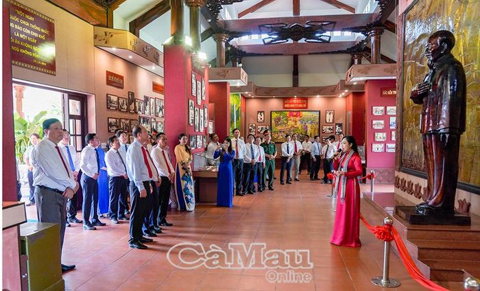 Các đồng chí lãnh đạo tỉnh Cà Mau nghe thuyết minh viên Bảo tàng tỉnh - Phan Ngọc Mai giới thiệu về quá trình xây dựng Đền thờ Bác Hồ.