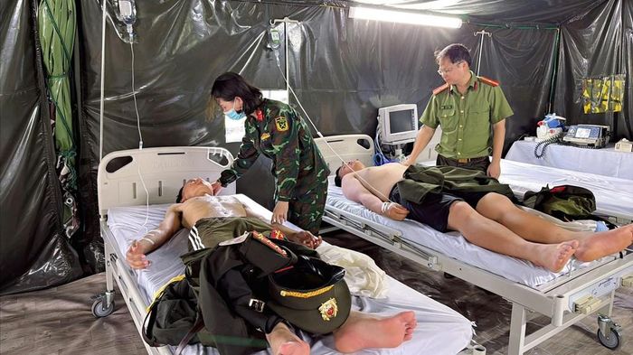 Thiếu tá, bác sĩ Đỗ Thái Nam (Bệnh viện 19.8) và nữ điều dưỡng Bệnh viện 103 đang chăm sóc, truyền nước, bù điện giải cho các chiến sĩ