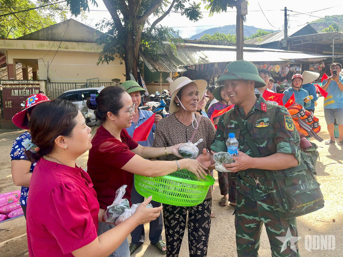  Những chai nước, món quà, cái bắt tay của bà con bản Suối Lư như lời cảm ơn, động viên bộ đội. Ảnh: LƯƠNG XUÂN 