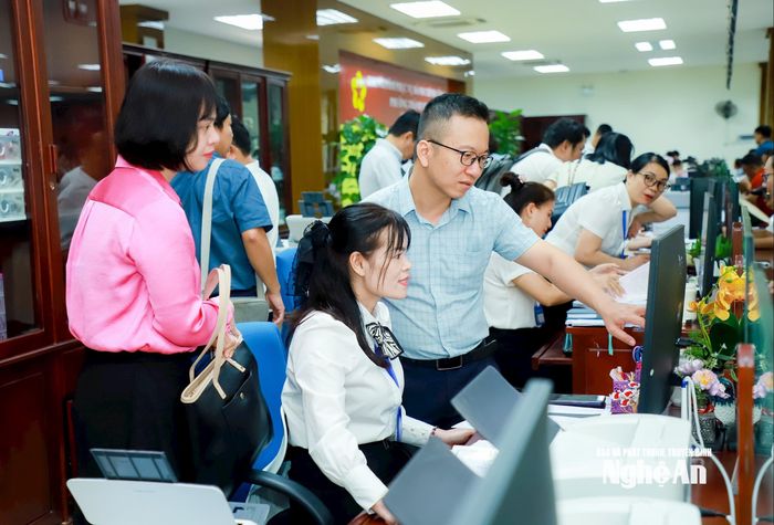Cán bộ Văn phòng Chính phủ, thành viên đoàn kiểm tra trực tiếp kiểm tra quy trình tiếp nhận, xử lý và trả kết quả thủ tục hành chính tại Trung tâm Phục vụ hành chính công phường Thành Vinh. Ảnh: Thành Duy