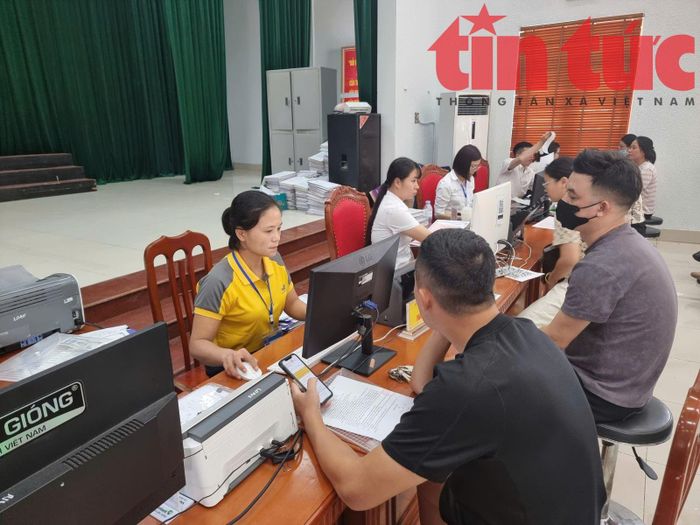 Cán bộ Bưu điện hỗ trợ người dân làm thủ tục trực tuyến.