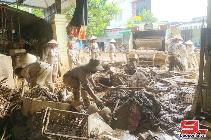 Công nhân Chi nhánh đô thị Sông Mã hỗ trợ các gia đình thu gom rác thải sau mưa lũ.