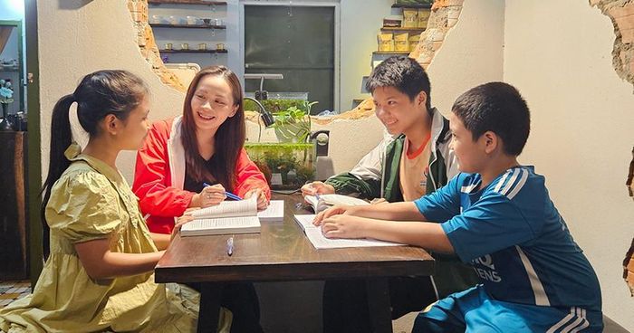  Chị Trần Bích Hằng (thứ 2 từ trái sang) tạo không khí vui tươi trong lớp học ngoại ngữ tại quán cà phê Bây giờ và ở đây. Ảnh Ngọc Duy 