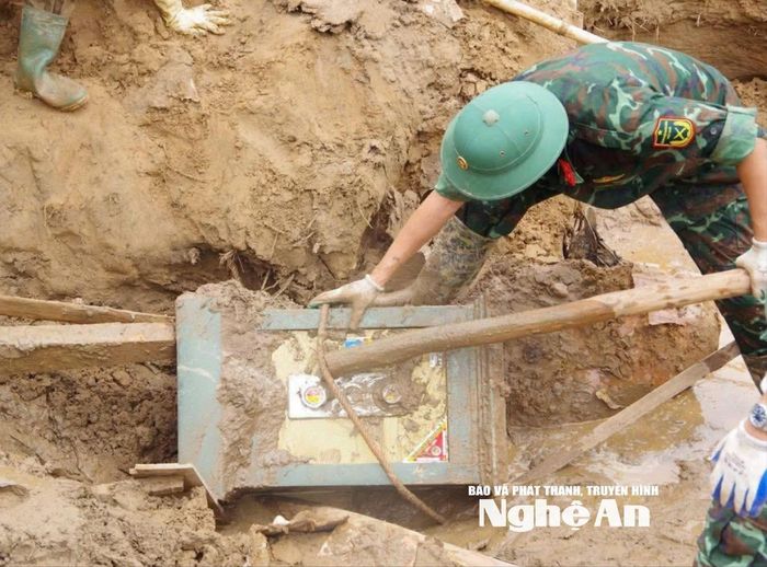 Lực lượng chức năng tìm thấy két sắt của người dân bị vùi lấp trong quá trình dọn dẹp, khắc phục hậu quả. Ảnh: tư liệu