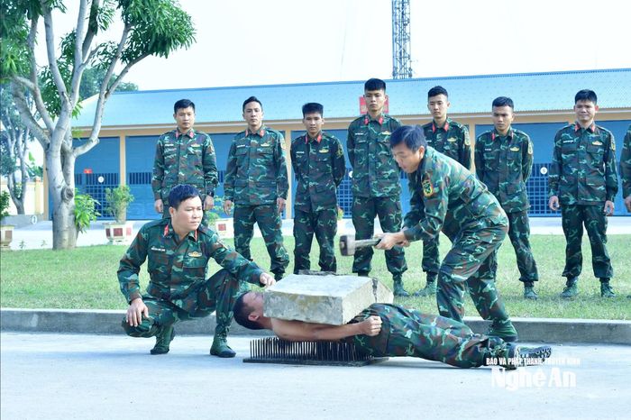 Người lính trinh sát với thân thể cứng như thép, nằm trên bàn chông làm "giá đỡ" đập vỡ tảng đá. Ảnh Trọng Kiên