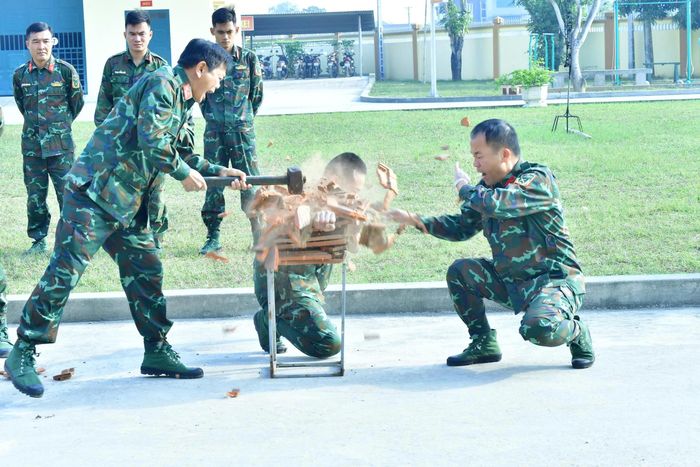 Nhờ chăm chỉ khổ luyện mà cánh tay chiến sĩ trinh sát có thể nằm giữa 10 lớp ngói và chịu được lực đập của búa sắt. Ảnh:Trọng Kiên
