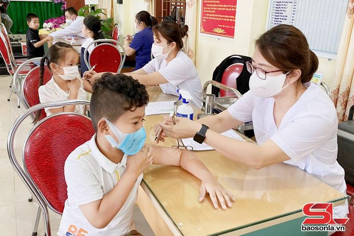 Cán bộ Trung tâm y tế khu vực Mộc Châu tiêm phòng cho trẻ.