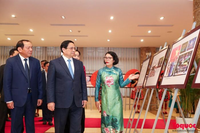 Thủ tướng Chính phủ Phạm Minh Chính và Bộ trưởng Bộ VHTT&amp;DL Nguyễn Văn Hùng, cùng các đại biểu xem nghệ nhân trình diễn trong không gian trưng bày ảnh về thành tựu của ngành VHTTDL năm 2023. Ảnh: Báo Tổ quốc.