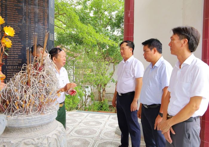 Lãnh đạo xã Hưng Nguyên Nam trao đổi với thủ từ kiêm quản lý quần thề di tích lịch sử - văn hóa đền Xuân Hòa và bia tưởng niệm liệt sĩ của xã. Ảnh: CSCC