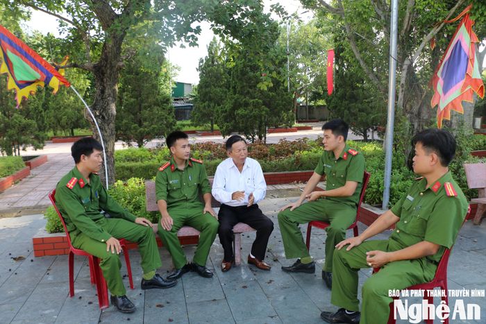 Quản lý kiêm thủ từ đền Xuân Hòa trao đổi với đoàn viên Chi đoàn Công an xã Hưng Nguyên Nam về những sự kiện lịch sử diễn ra tại đây. Ảnh: GH