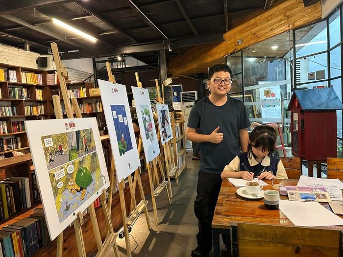 Họa sĩ Linh Rab bên học trò nhí và tranh về Dế Út