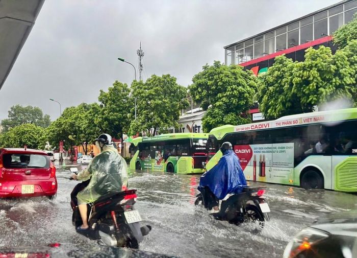 Mưa lớn tiếp tục trút xuống vào giờ đi làm gây rất nhiều khó khăn cho việc di chuyển của người dân. Ảnh: Tuấn Anh - TTXVN