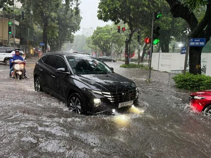 Mưa xối xả khiến nhiều tuyến đường nhanh chóng biến thành "sông". Ảnh: Lâm Khánh - TTXVN