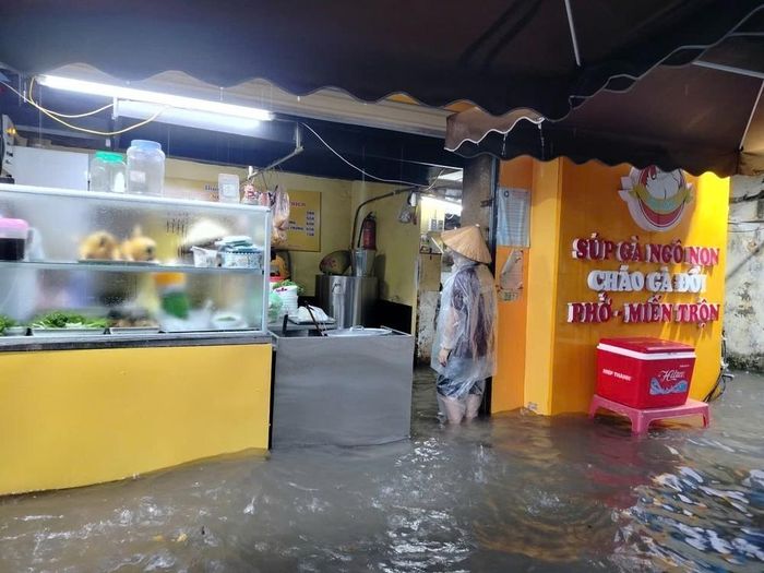Phố Quang Trung ngập sâu ảnh hưởng trực tiếp đến cuộc sống của người dân. Ảnh: Hoàng Hiếu - TTXVN
