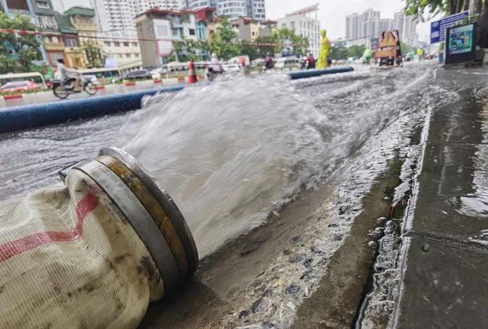 Công nhân ứng trực, xử lý thoát nước trên phố Minh Khai. Ảnh: Thanh Tùng - TTXVN