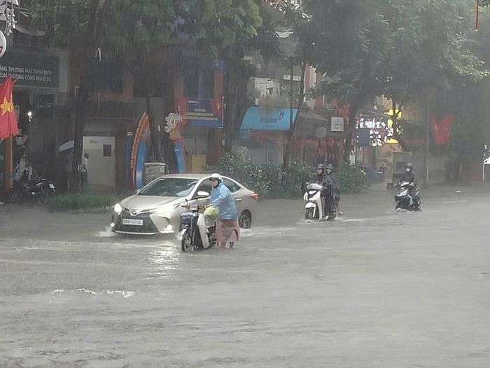 Mưa xối xả khiến nhiều tuyến đường nhanh chóng biến thành "sông". Ảnh: Hoàng Hiếu - TTXVN