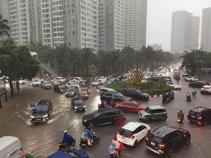 Mưa lớn ảnh hưởng đến việc di chuyển của người dân đầu giờ sáng tại KĐT Times City. Ảnh: Thanh Tùng - TTXVN