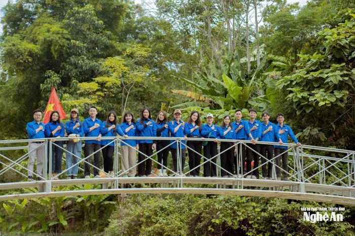Anh Nguyễn Huy Hoàng (bên trái) tại cầu dân sinh vượt suối do Hội Đồng hương thanh niên Nghệ An tại Hà Nội trao tặng bà con ở xã Cắm Muộn (cũ), nay là xã Mường Quàng cùng hệ thống đèn năng lượng mặt trời và cầu dân sinh với tổng giá trị trên 350 triệu đồng. Ảnh: Thanh Quỳnh