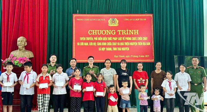 Đại diện lãnh đạo Phòng Cảnh sát Phòng cháy, chữa cháy và Cứu nạn, cứu hộ tặng bình chữa cháy cho các hộ dân và quà cho các cháu học sinh.