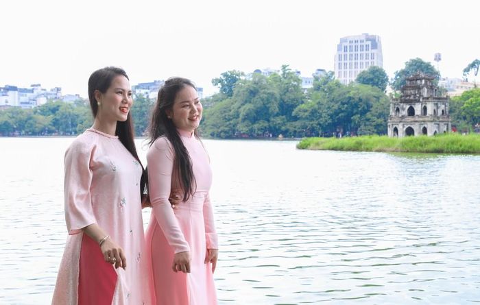 Người dân rạng rỡ chụp ảnh tại khu vực hồ Hoàn Kiếm. Ảnh: Thành Phương - TTXVN