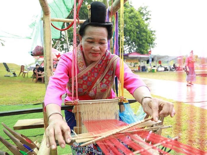 Bàn tay khéo léo của người phụ nữ Lào bên khung cửi, lưu giữ nét đẹp văn hóa dệt vải truyền thống. Ảnh: Vân Chi/TTXVN