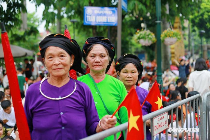 3 chị em dâu đến từ Lào Cai rất vui vì ngoài được các chú công an sắp xếp chỗ ngồi đẹp còn được tặng ô che mưa, cờ và cơm trong lúc chờ đợi.