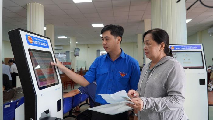 Thanh niên tình nguyện phường Rạch Giá (An Giang) hướng dẫn người dân đăng ký giải quyết thủ tục hành chính trên hệ thống.