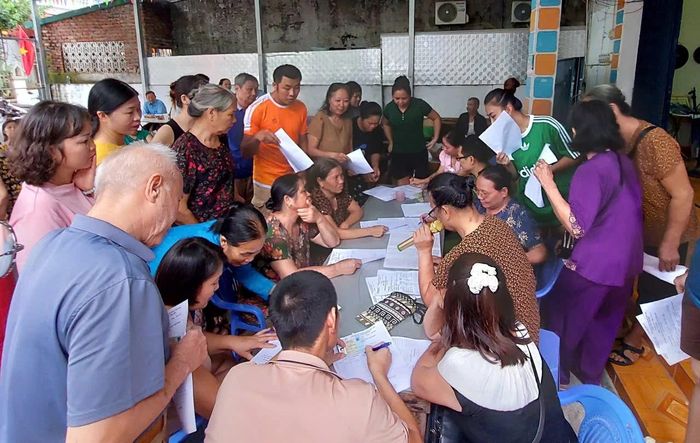 Người dân đến nhà văn hóa kê khai nhân khẩu và phấn khởi nhận được quà 100 nghìn đồng/người.