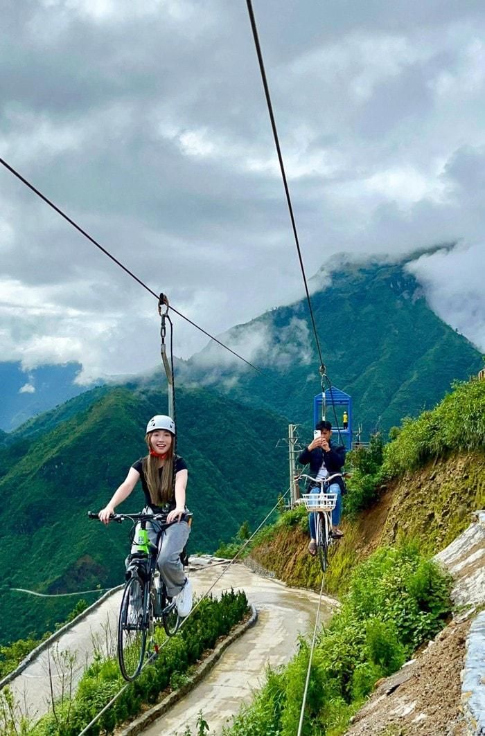 Du khách trải nghiệm đi xe đạp trên không ở Cổng trời Ô Quy Hồ. Ảnh: TL