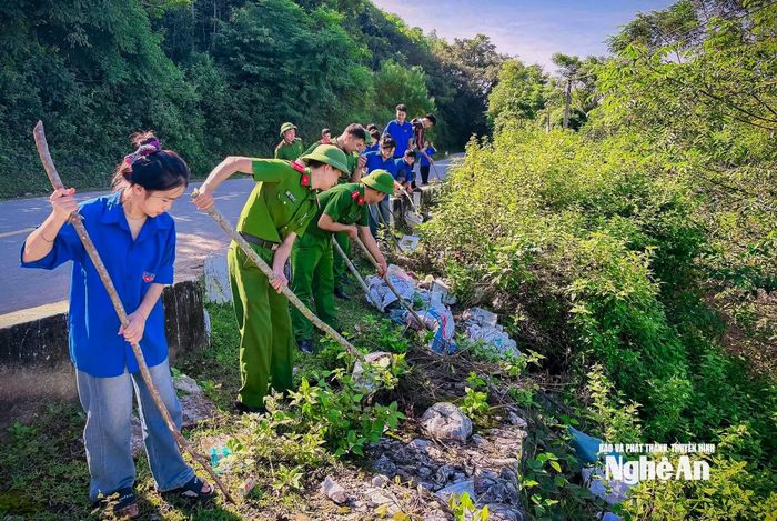 Các cán bộ, chiến sĩ công an và đoàn viên thanh niên xã Hùng Chân thực hiện vệ sinh môi trường. Ảnh: Kế Kiên